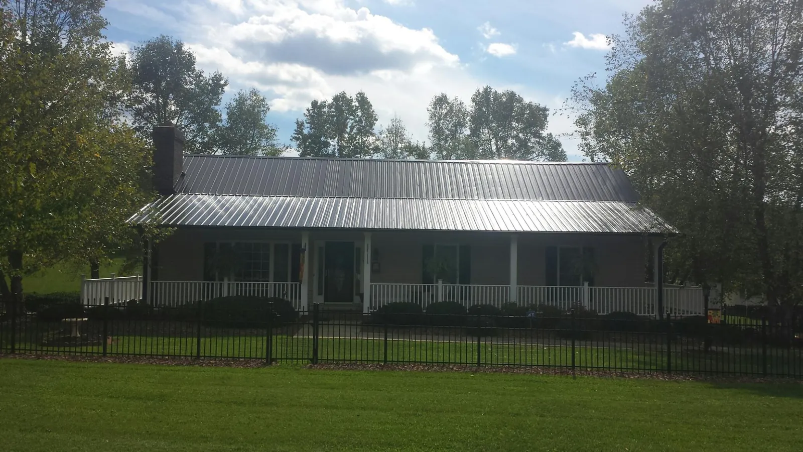 Gray metal roof on a brick ranch with a full width front porch — Gutter Guard Installation work by our crew in Yacolt